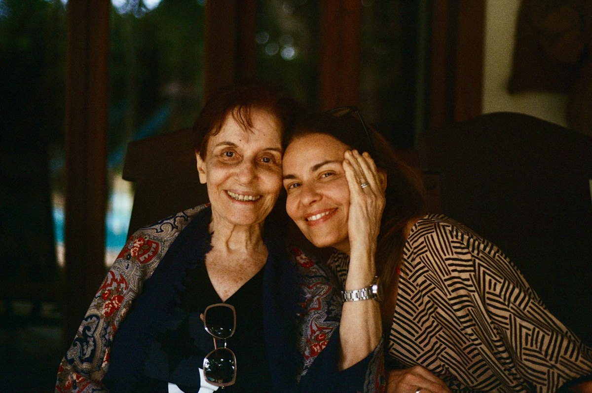 Madre mayor e hija abrazadas, sonriendo